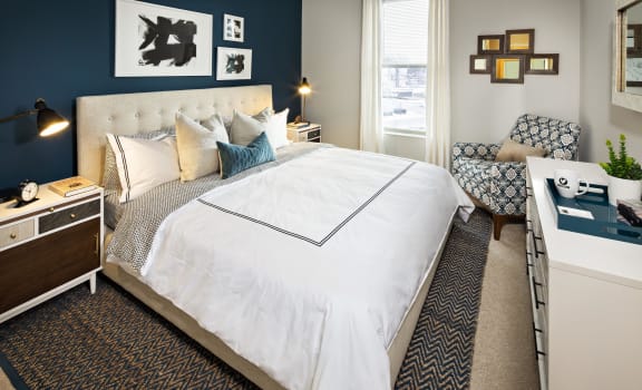 a bedroom with a large white bed and a blue accent wall
