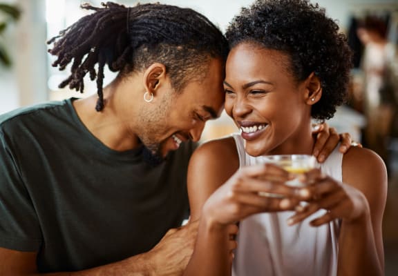 a man and a woman smiling and holding a glass of wine