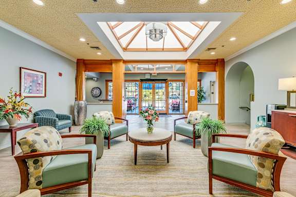 A spacious waiting area with wooden furniture and a glass ceiling.