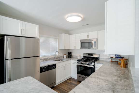 A kitchen with black appliances and white cabinets.