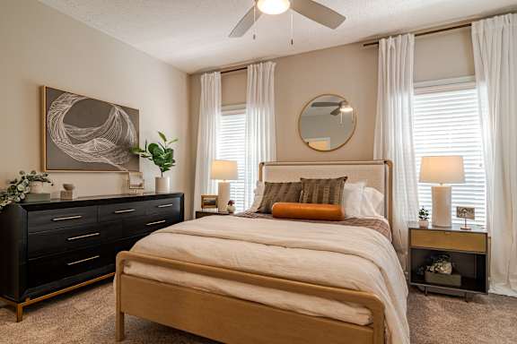 A living room with a grey couch and a wooden entertainment unit.