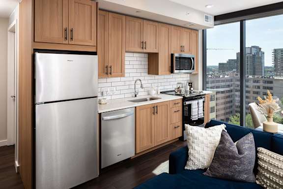 A modern kitchen with a refrigerator, sink, and microwave at 903 Peachtree in Atlanta, GA