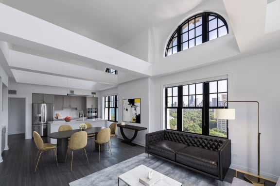 a living room with a black leather couch and a table with chairs at the Belden Stratford in Chicago, 60614