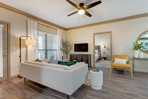 a living room with a couch and a ceiling fan at Summerwind in Pearland, Texas 77584