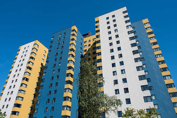 A tall building with a blue and yellow facade stands against a clear sky at Skye at Belltown Apartments, Washingto