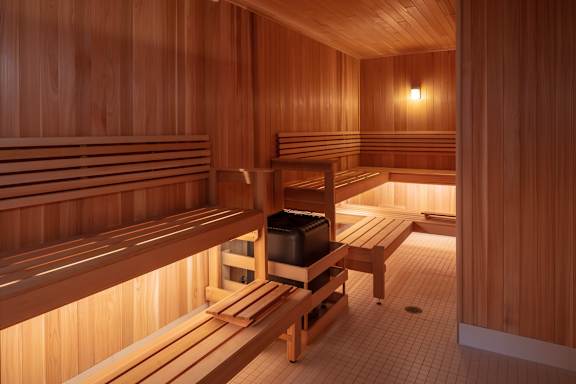 Wooden sauna room with benches and a table at 365 Nicollet, Minneapolis, Manchester