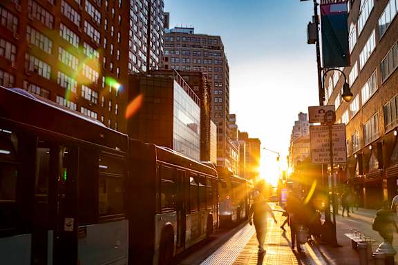 people walking down a city street at sunset