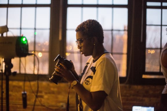 a woman standing in front of a camera holding a camera