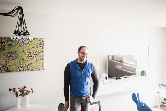 a man standing in a room with a desk and a tv