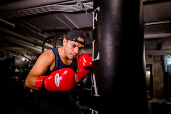 a man wearing red boxing gloves in a gym