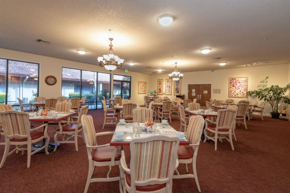 a dining room table with chairs and a clock on the wall