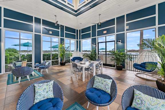 A sunroom with blue chairs and a table.