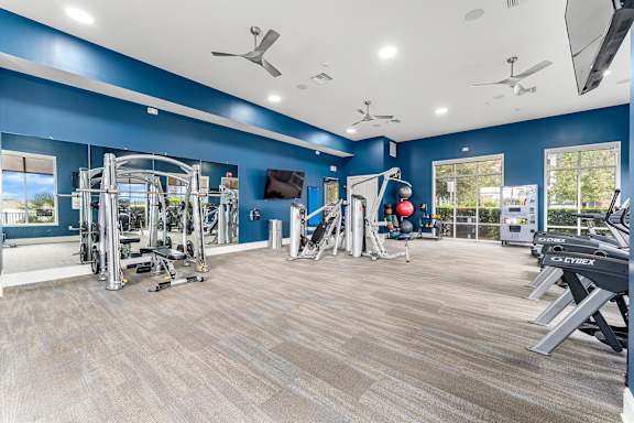 A spacious gym with a variety of equipment and a flat screen TV.