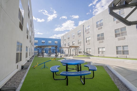 a playground and picnic area in the courtyard of an apartment building at The Onyx at 695, Nevada, 89503