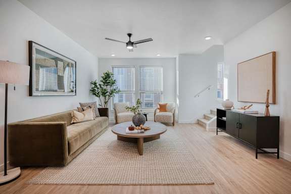 A living room with a brown sofa, a coffee table, and a painting on the wall.