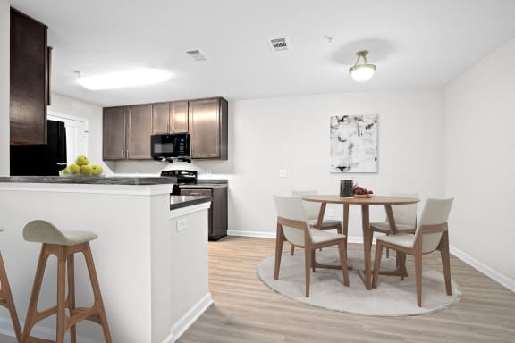 a kitchen and dining area with a small table and chairs in a home