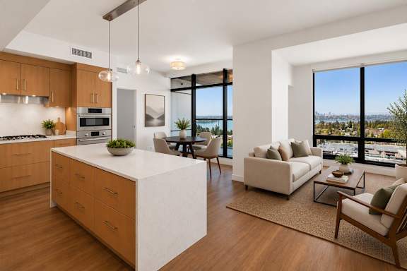 A modern kitchen with a large island and a view of the city.