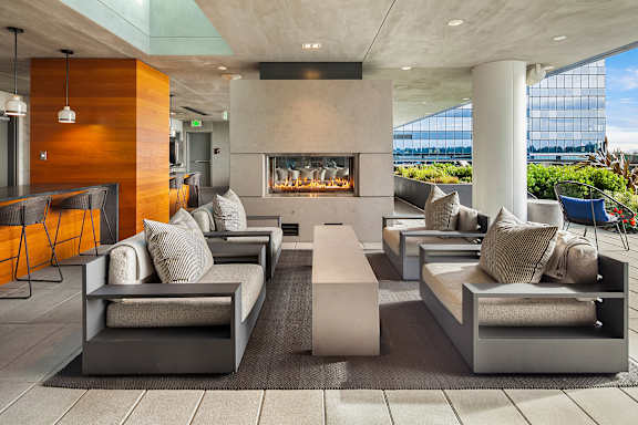 A modern living room with a fireplace and a view of the water.