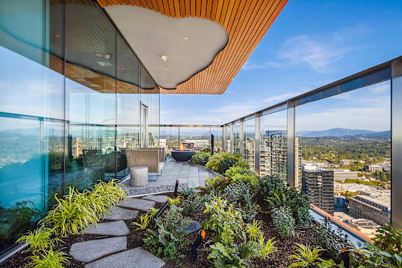 A modern building with a glass balcony overlooking a cityscape.