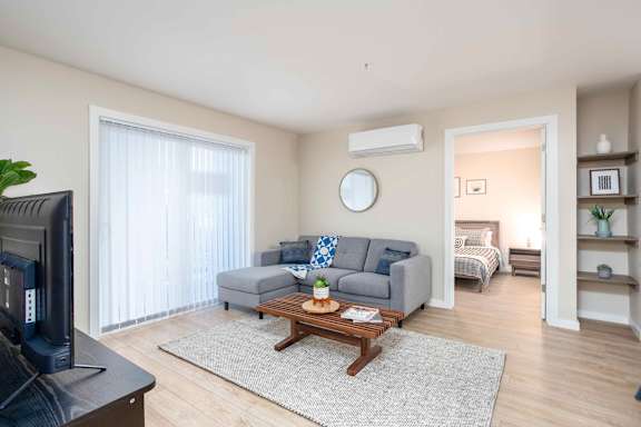 A living room with a grey couch and a wooden coffee table at G17 Apartments at Tamarack, Edmonton, AB