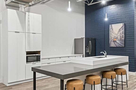 Modern kitchen with white cabinets and a grey countertop at Brickside Heights, Utah