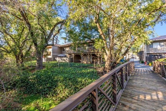 exterior of apartments, bridge, and landscaping