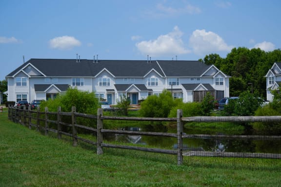 a large blue house with a wooden fence in front of it