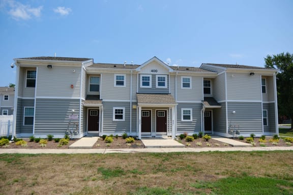 front view of an apartment building with sidewalks and grass