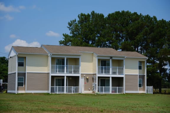 an apartment building with a yard in front of it