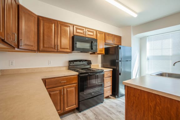 a kitchen with wooden cabinets and black appliances