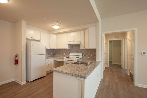 a kitchen with white appliances and granite counter tops