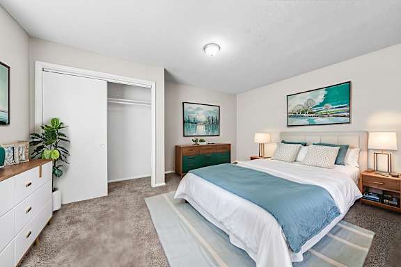 A bedroom with a large bed and a painting on the wall.at Signature Collection, Tuscaloosa, AL