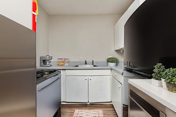 A kitchen with a stainless steel refrigerator and white cabinets.at Signature Collection, Tuscaloosa