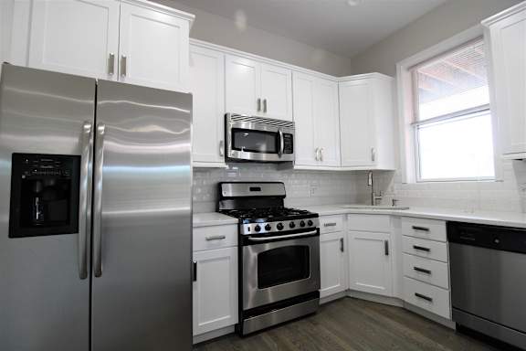 a kitchen with stainless steel appliances and white cabinets