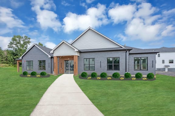 the front of a house with a lawn and a sidewalk
