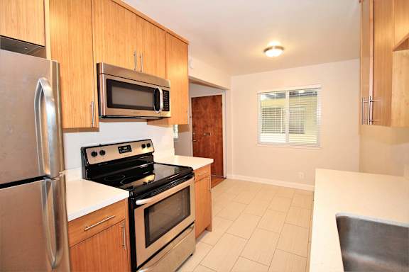 a kitchen with stainless steel appliances and wooden cabinets