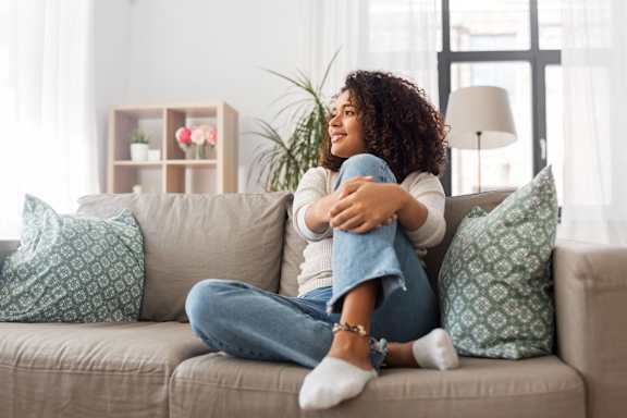a woman sitting on a couch with her legs crossed
