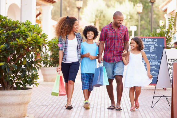 a family walking down the street with shopping bags