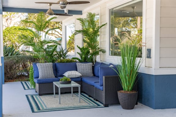 a porch with blue furniture and potted plants