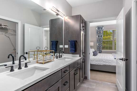 A bathroom with a white sink and a mirror above it.