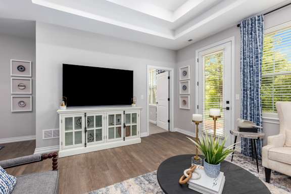 A living room with a flat screen TV on a cabinet.