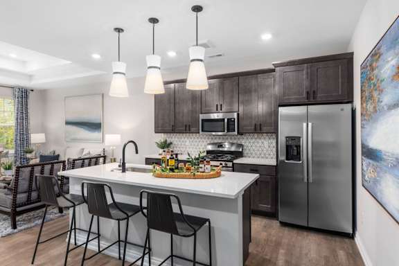 A modern kitchen with a large island and stainless steel appliances.