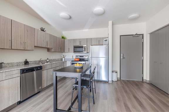 A kitchen with a table and chairs in the middle of it.