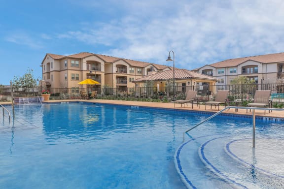 a large swimming pool with a building in the background at Mariposa at Clear Creek Webster 55+ Apartments, Webster, 77598