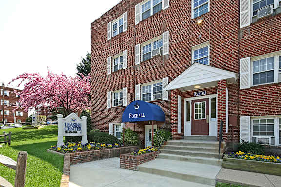 A brick building with a blue awning and a sign that says Foghall.