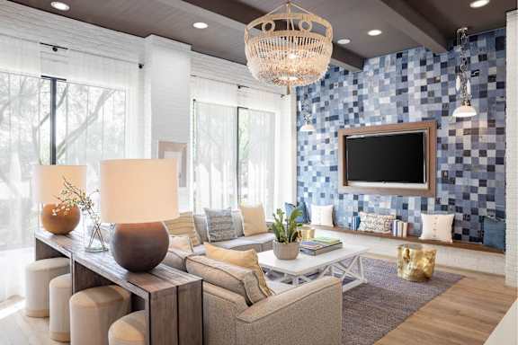 A modern living room with a large sofa, a wooden coffee table, and a chandelier.