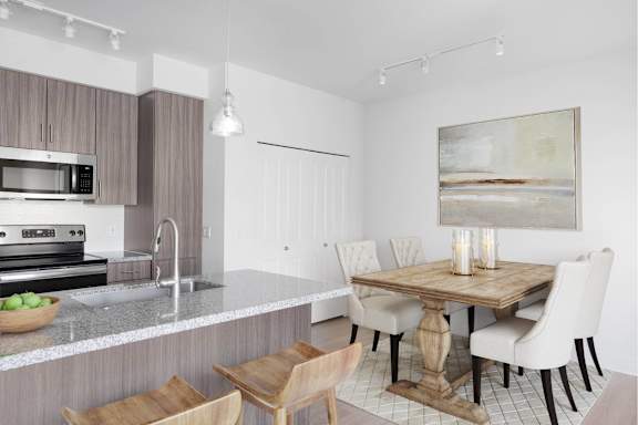 A modern kitchen with a wooden table and chairs.
