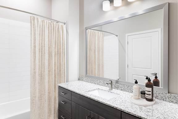 A bathroom with a white sink and a mirror.