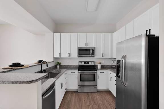 A modern kitchen with stainless steel appliances and white cabinets.