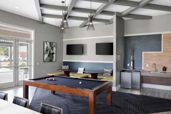 A room with a pool table and a television.